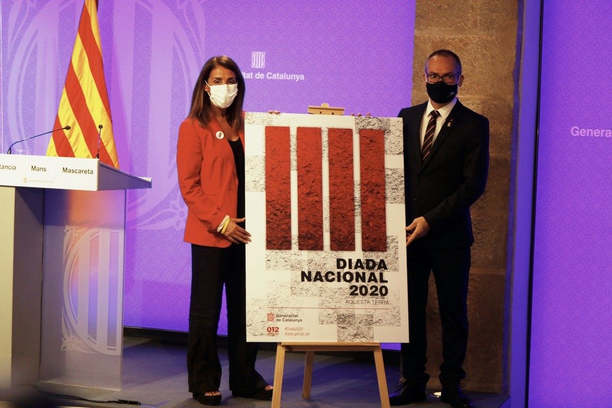 La portaveu del Govern, Meritxell Budó, i el vicepresident primer del Parlament, Josep Costa, amb el cartell de la Diada