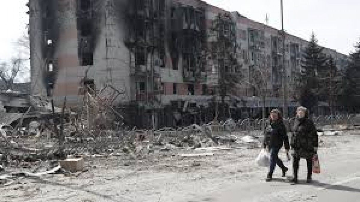 Dues dones passejant per Mariupol, en una estranya normalitat després d'un bombardeig rus.