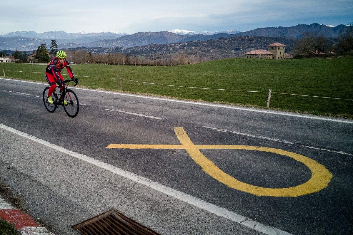 Un ciclista passa al costat d'un llaç groc pintat a la carretera C-153, a Cantonigròs