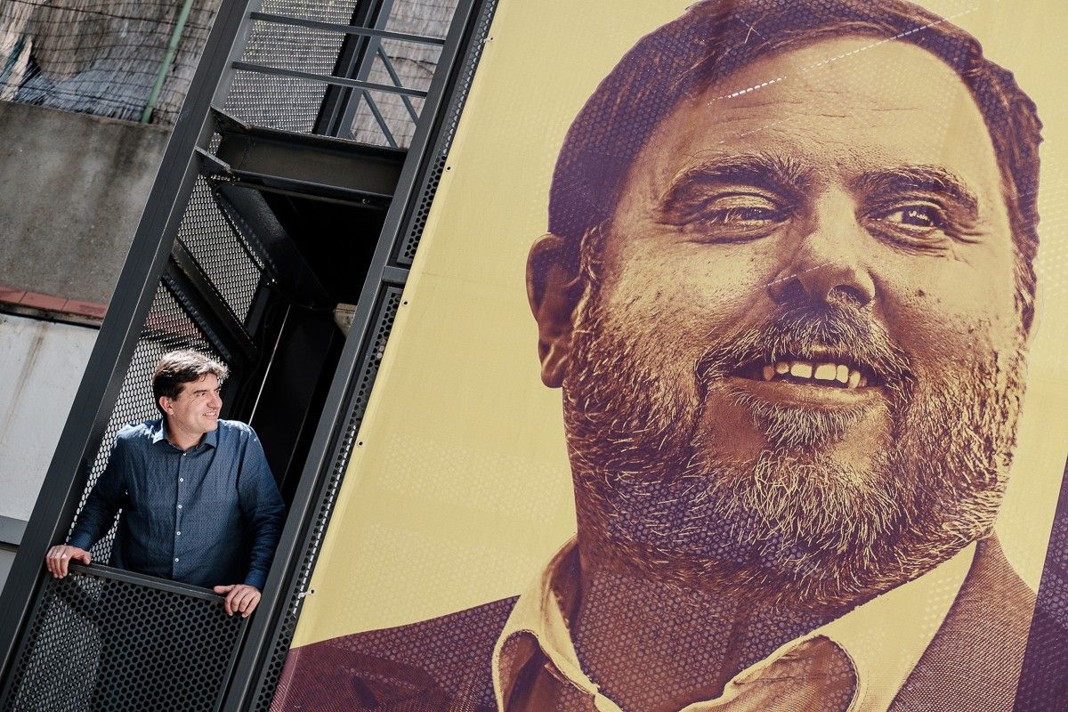 Sergi Sabrià, al costat d'una lona amb la foto d'Oriol Junqueras, a la seu d'ERC.