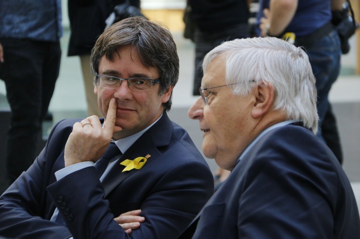 L'expresident de la Generalitat Carles Puigdemont conversa amb un dels seus advocats abans de la roda de premsa 