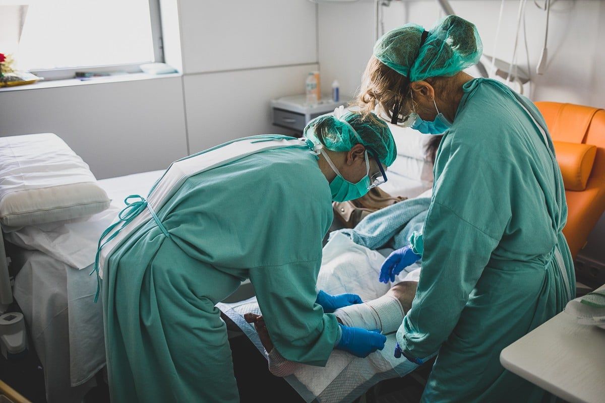 Dues infermeres atenent un pacient a l'Hospital d'Olot