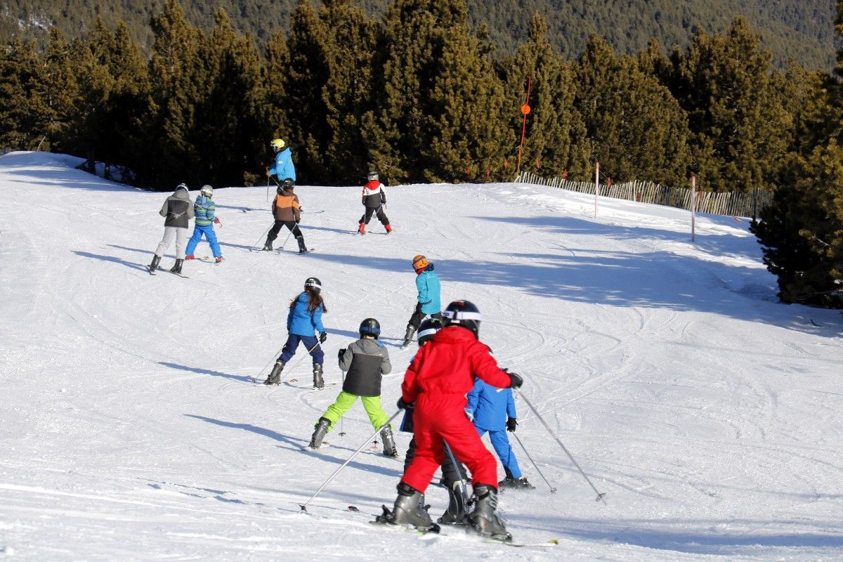  Un grup d'alumnes amb un monitor fent classes d'esquí a Port del Comte