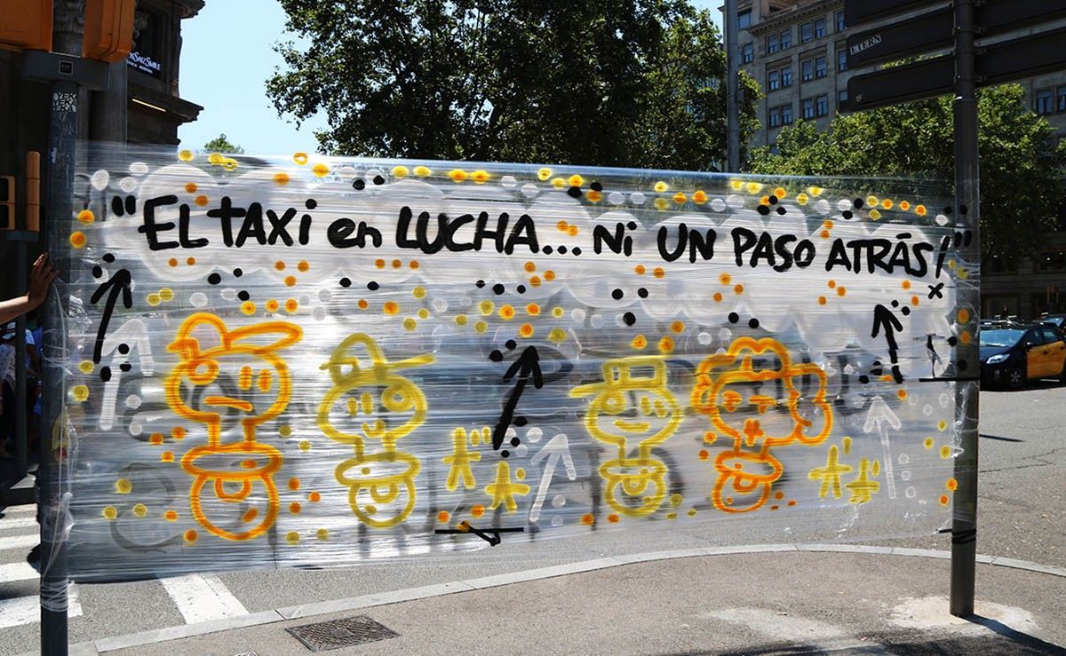 Una pancarta que diu «El taxi en lluita, ni un pas enrere» a la Gran Via