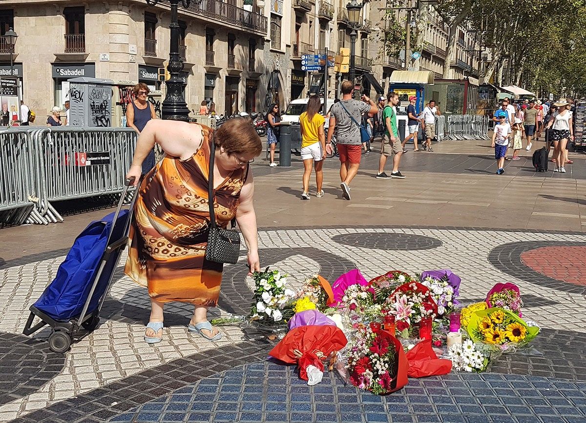 Cèlia Gurmaches diposita un ram de flors a la Rambla en record de les víctimes del 17-A, aquest dijous