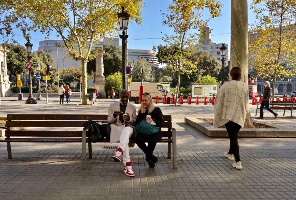 Ciutadans prenent un cafè en un banc de Barcelona