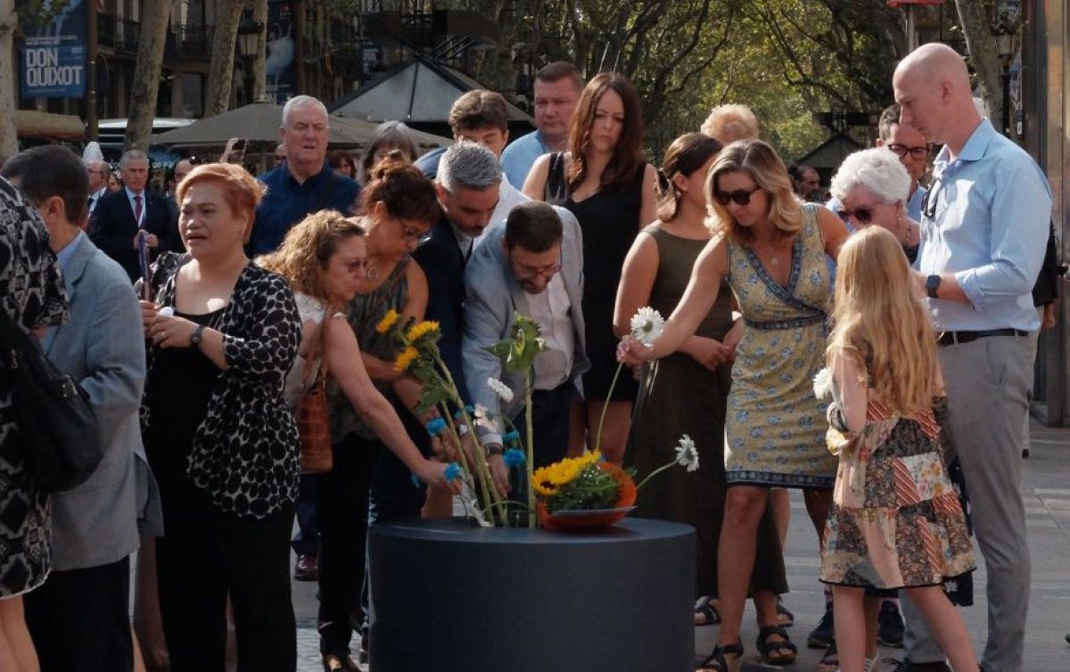 Víctimes i familiars en una ofrena floral davant del mural de Joan Miró a la Rambla.