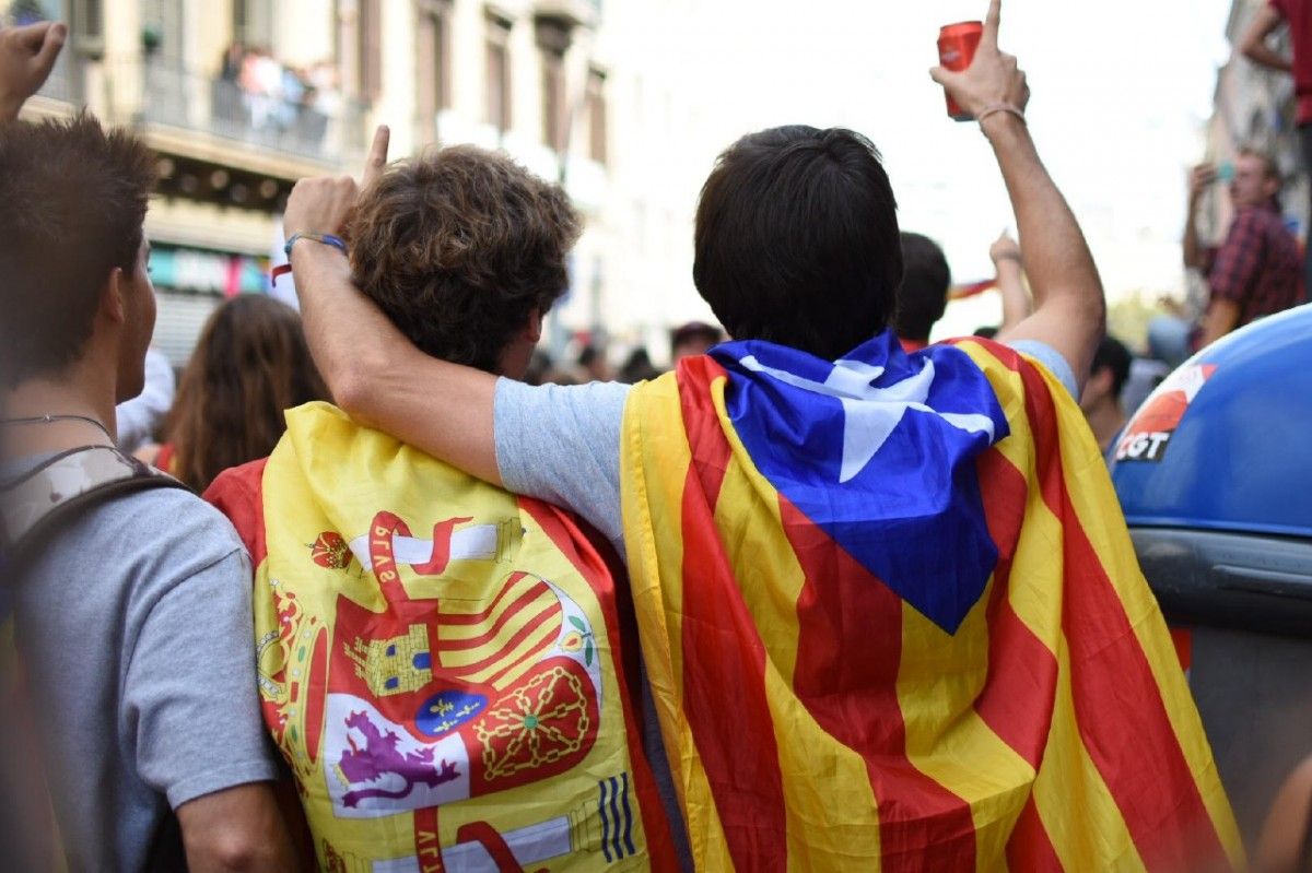 Dos joves amb una bandera espanyola i una estelada, durant el 3 d'octubre de 2017.