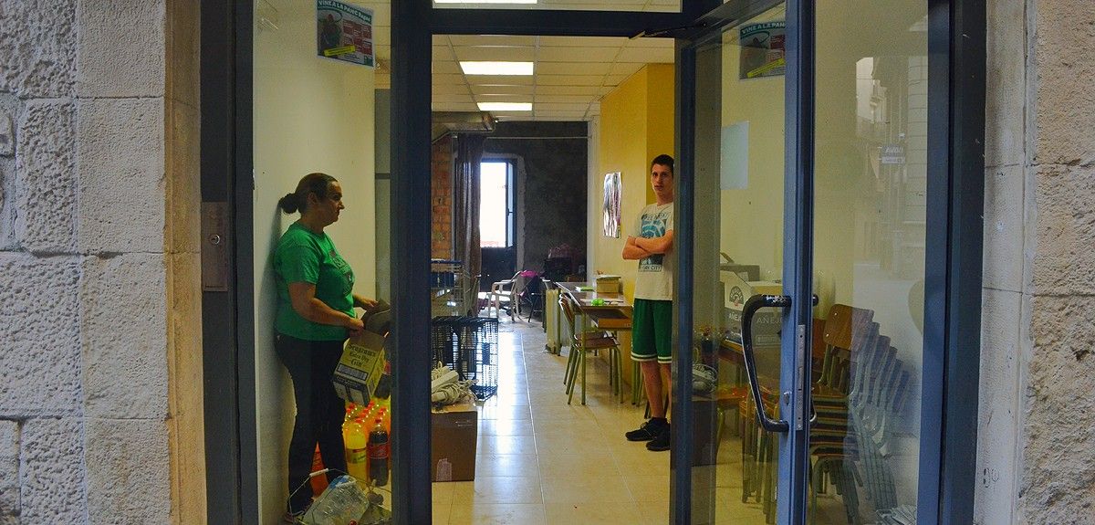Dos voluntaris endreçant el local que acollirà l'Escola Popular de Manresa, aquest dilluns